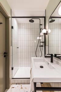 a white bathroom with a shower and a sink at Faern Arosa Altein in Arosa