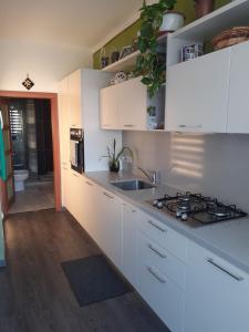 a kitchen with white cabinets and a stove top oven at Cosy Home by the Sea in Birżebbuġa