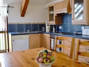 a kitchen with a table with a bowl of fruit on it at Bats Roost - Hkkp in Lynton