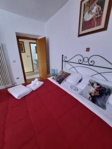 1 dormitorio con 1 cama con colcha roja en Le Pleiadi, en Bieno