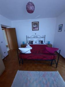a bedroom with a red bed with white pillows at Le Pleiadi in Bieno