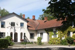 uma casa branca com um telhado vermelho em Borregården Bed & Breakfast em Borrby