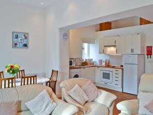 a kitchen and living room with two couches and a table at The Cobbles in West Pennard