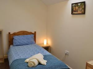 een slaapkamer met een bed met een handdoek erop bij The Cobbles in West Pennard