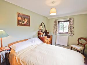 a bedroom with a large white bed and a window at The Stables - E3491 in Saxtead