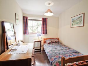 um quarto com uma cama, uma secretária e uma mesa em The Stables - E3491 em Saxtead