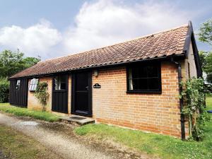 a small brick house with a black door at The Stables - E3491 in Saxtead