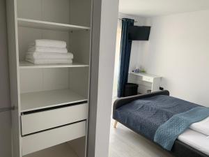 a bedroom with a closet with white shelves and a bed at Vila Victory in Tohanu Nou