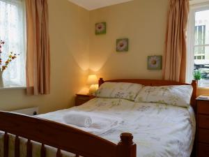 a bedroom with a bed and a window at Hen Ysgubor - 29518 in Fairbourne