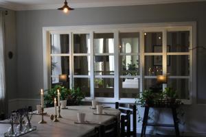 a dining room with a table and a large window at Borregården Bed & Breakfast in Borrby