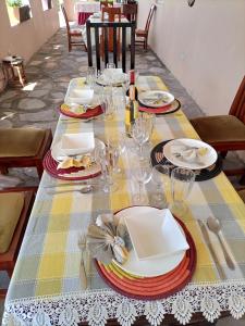 a table with plates and glasses on top of it at Pross Residence in Masindi