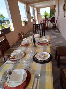 a table with plates and glasses on top of it at Pross Residence in Masindi