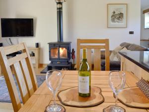 LlanfrothenにあるBwthyn Llwynog - HW7739のワイングラス2杯付きのテーブルに座ったワイン1本