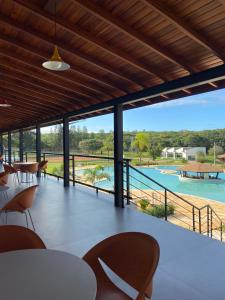 um pátio com mesas e cadeiras e vista para uma piscina em Vale Das Águas Fazenda Resort em Águas de Santa Barbara