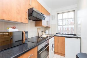 a kitchen with a sink and a stove at Marble Arch Serviced Apartments in London