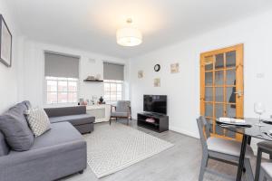 a living room with a couch and a table at Urban Hyde Park One-Bedroom Retreat in London