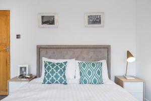 1 dormitorio con 1 cama con almohadas azules y blancas en Urban Hyde Park One-Bedroom Retreat, en Londres