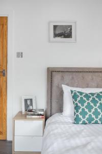 1 dormitorio con 1 cama y mesita de noche con una almohada verde en Urban Hyde Park One-Bedroom Retreat, en Londres