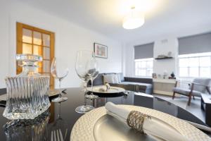 a table with two wine glasses and a living room at Marble Arch Serviced Apartments in London