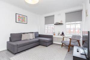 a living room with a couch and a table at Urban Hyde Park One-Bedroom Retreat in London