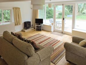 a living room with a couch and a television at Winhill Cottage in Bamford