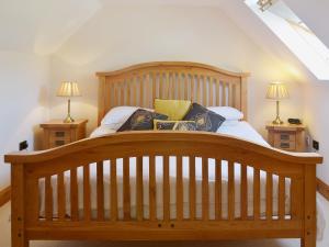 a bedroom with a wooden bed with two night stands at Beer Farm in Stawley