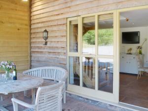 a patio with a table and chairs and sliding glass doors at Beer Farm in Stawley