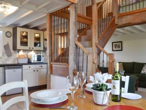 a dining room table with wine glasses and a kitchen at Orchard Chapel in Much Marcle