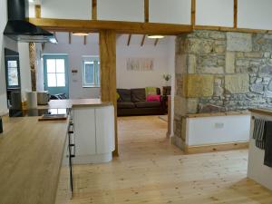 a kitchen and living room with a stone wall at No2 The Neuk in Belford