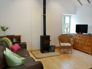 a living room with a couch and a wood stove at No2 The Neuk in Belford