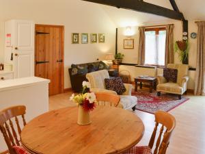 cocina y sala de estar con mesa de madera en Church Barn Studio en Brundall