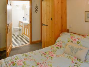 1 dormitorio con 1 cama y baño con lavamanos en Church Barn Studio en Brundall