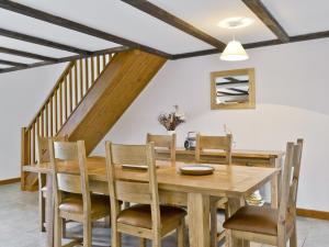 uma sala de jantar com uma mesa de madeira e cadeiras em Coriander - E4323 em Ludham