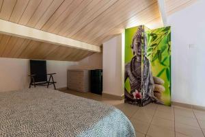 un dormitorio con una gran pintura de un buddha en la pared en Bella Vista , à Porticcio, joli appartement vue mer, en Grosseto-Prugna
