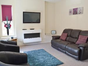 a living room with a couch and a tv at Chapel View in Filey