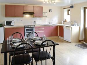 a kitchen with a table and chairs in a kitchen at The Cottage - 28645 in Alston
