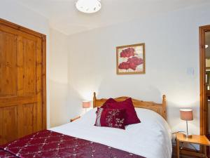 a bedroom with a bed and a clock on the wall at The Cottage - 28645 in Alston