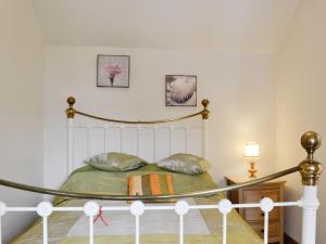 a bedroom with a white bed with green sheets at Lily Vale Cottage in Hendy