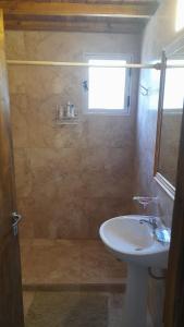 baño con lavabo y ducha con ventana en La Gemelita en Capilla del Monte