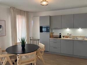 a kitchen with a table and chairs and a kitchen with white cabinets at Résidence Services CAZAM in Clermont-Ferrand