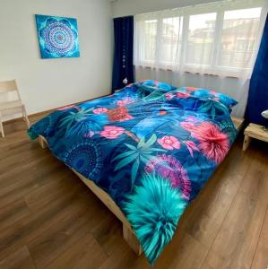 a bed with a blue comforter with flowers on it at Natalies Hideaway in Thun