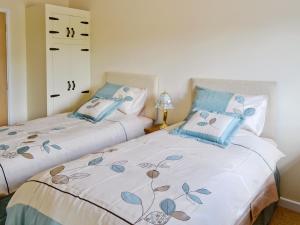 two beds sitting next to each other in a bedroom at Woodlanders - 29954 in Wootton Glanville
