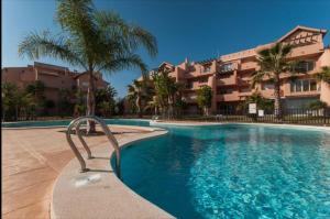 a swimming pool in front of a building at Spacious luxe apartment on Mar Menor Golf Resort with Padel, Fitness, Wellness facilities in Torre-Pacheco