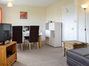 uma sala de estar com um sofá e uma mesa com uma televisão em Beech Cottage em Ilfracombe