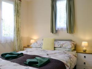 イフラクームにあるBeech Cottageのベッドルーム1室(ベッド1台、緑のタオル2枚付)