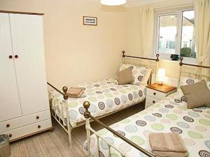 a bedroom with two beds and a window at Breedsmoor Cottage in Ore