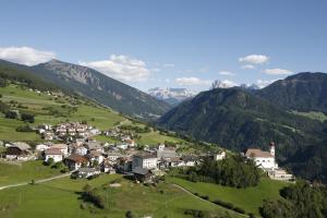 een klein dorpje in een groene vallei met bergen bij Haus Sonnegg Panoramasuite in Laion