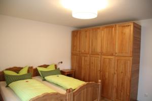 1 dormitorio con 2 camas y armario de madera en Alpen - Apartments en Garmisch-Partenkirchen