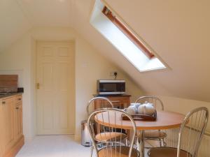 a kitchen with a table with chairs and a skylight at Swallows Nest in Crich