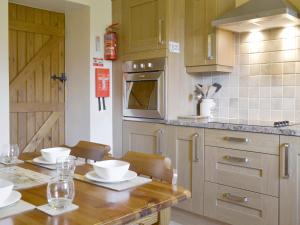 a kitchen with a wooden table with white bowls on it at Holly Bank in Crich